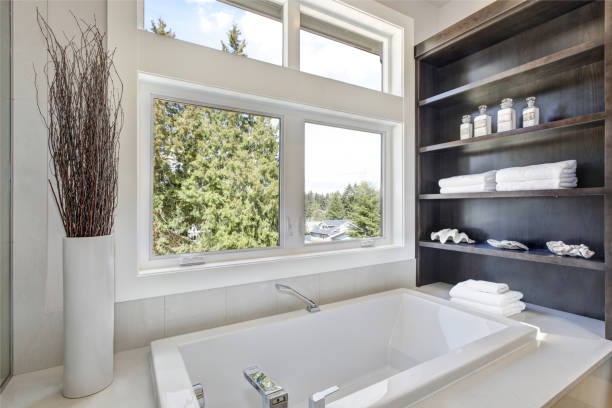 Lower level bathroom with electric metal security blind partially open.
