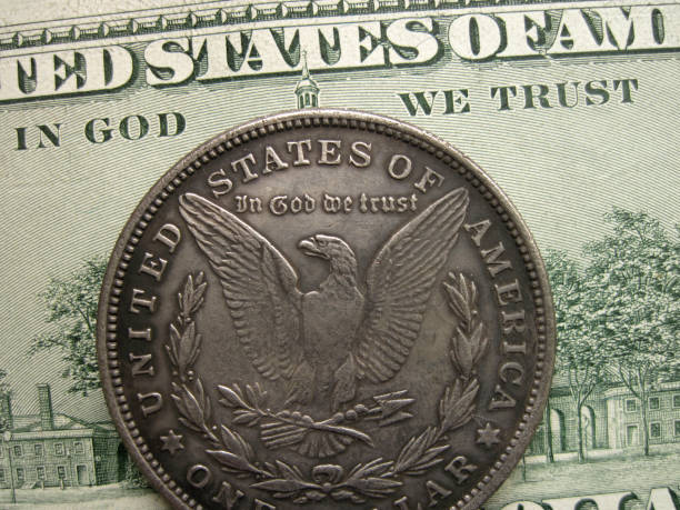 istock In God we trust on banknote and Morgan dollar coin 875394292