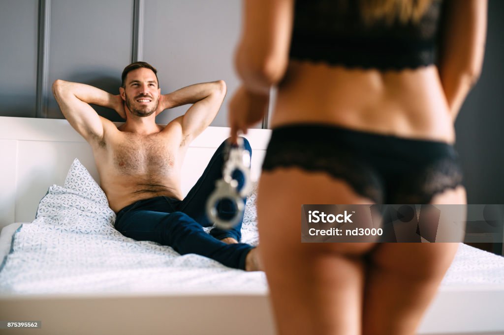 Woman and man playing domination games in bed Woman and man playing domination games in bed together Couple - Relationship Stock Photo