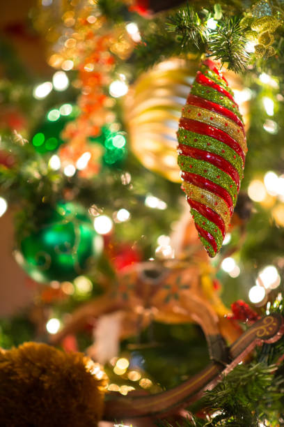 istock Multi-colored and glitter Christmas ornament hang on tree in selective focus 875405848
