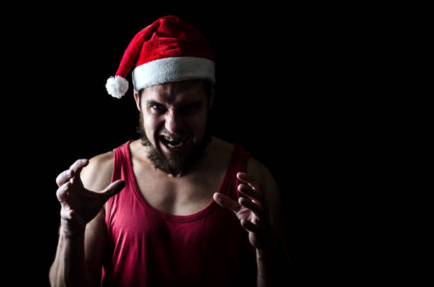 Evil, bad, scary Santa isolated on black background space. Angry man in Santa Claus hat.