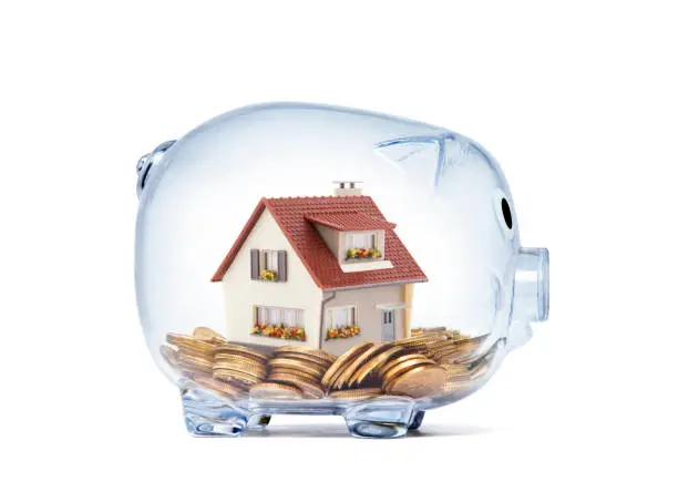 Photo of House on money inside transparent piggy bank with clipping path