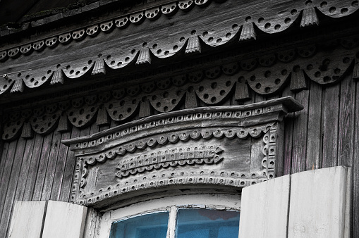 Fragment of a window of an old Russian wooden house with elements of carved ornaments in the old part of the city of Astrakhan (Russia) Urban architecture of the old Russian Empire.