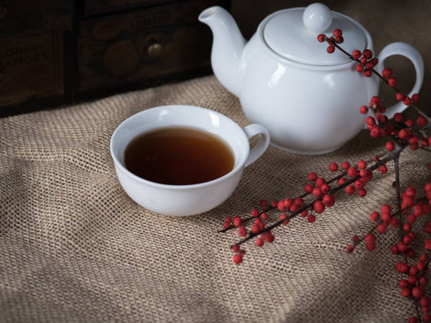 cup of hot tea and teapot on the retro background - кувшин imagens e fotografias de stock