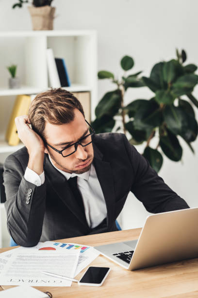 istock overworked businessman with laptop 875409622