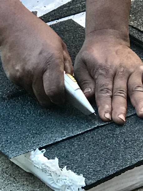 istock Cutting asphalt shingles with utility knife 875416146