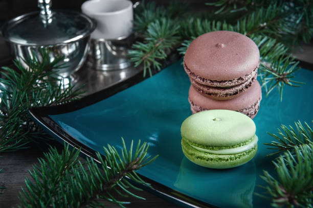 istock Fresh green and brown macaroons macaroons on Christmas table decorated with fir branches. Copy the place 875419762