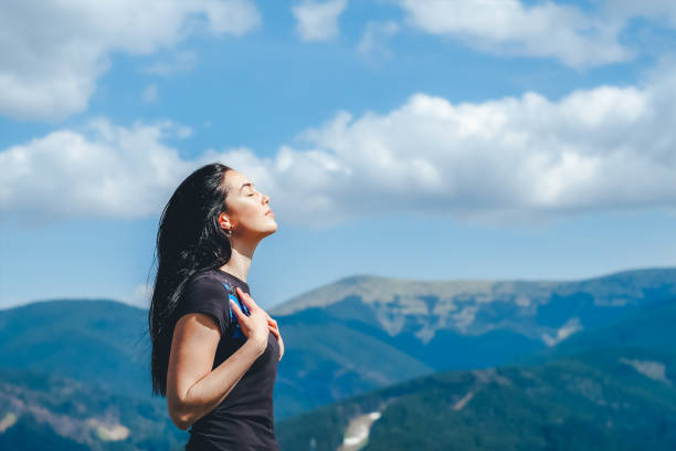 Long hair brunette girl on the top of the mountain Long hair brunette girl on the top of the mountain enjoying fresh air breath vapor stock pictures, royalty-free photos & images