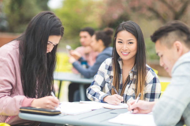 istock Multiethnic group of college students study outside at table together 875423540