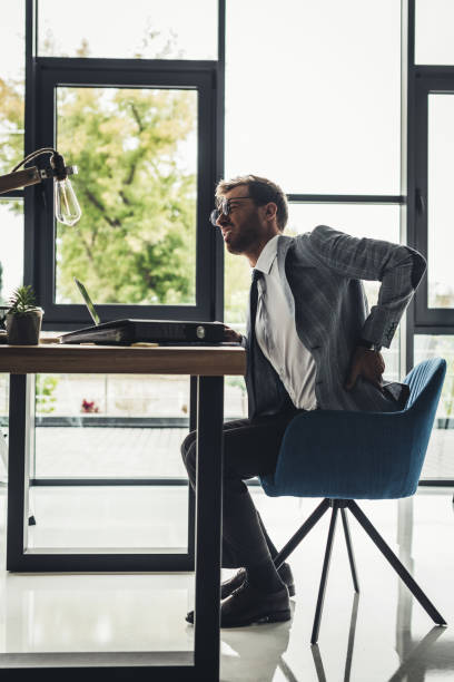 istock businessman with back pain 875427620