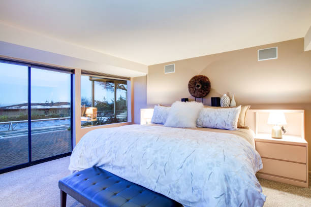 istock Lovely bedroom design with glass wall and exit to patio 875433624