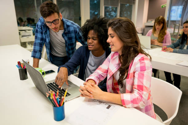 istock Young team of creatives working together on a design proyect looking very happy and smiling 875434710