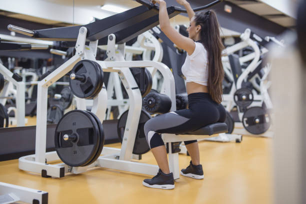 istock Female doing exercies on sports machine in gym 875437898