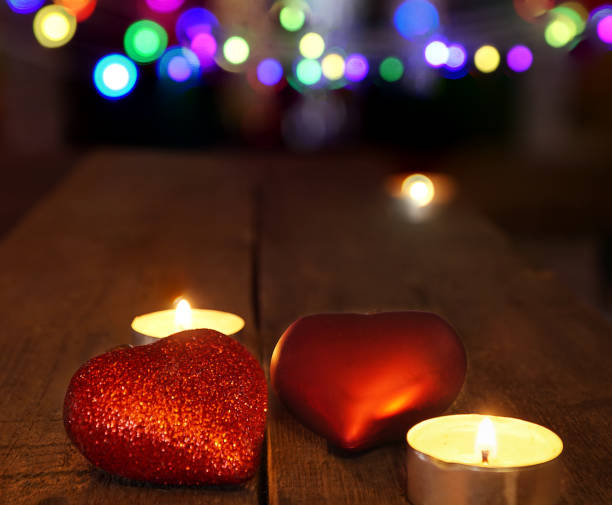 istock christmas decoration with candles and heart shape with blurred background. 875441624