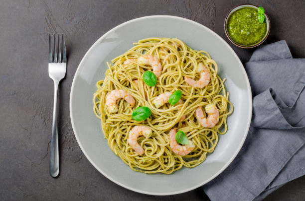 istock Spaghetti with fried prawns and pesto sauce in a gray plate, dar 875444246