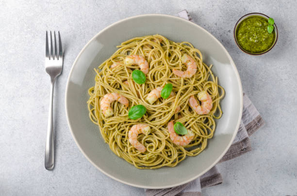 istock Spaghetti with fried prawns and pesto sauce in a gray plate, sto 875444418