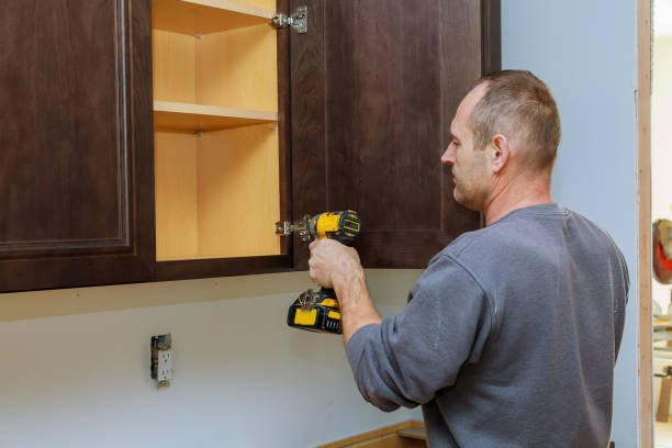 istock Handyman fixing kitchen's cabinet with screwdriver 875451160