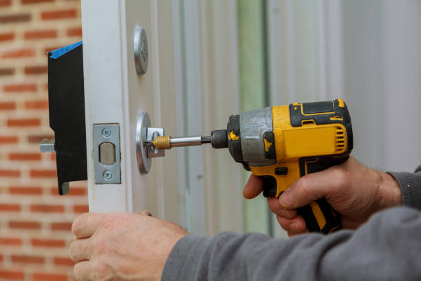 istock Install the door handle with a lock, Carpenter tighten the screw, using an electric drill screwdriver, 875451198