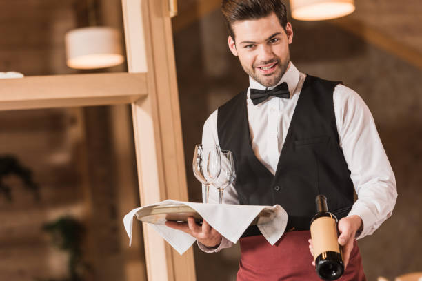 istock Waiter holding wineglasses and bottle 875461162