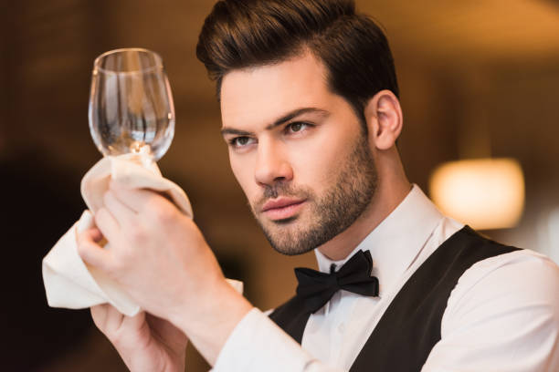 istock waiter looking at clean wineglass 875461286