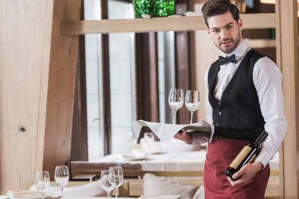 istock Waiter holding wineglasses and bottle 875461576