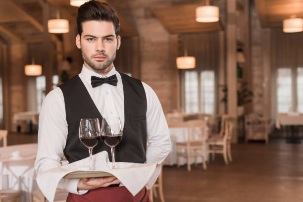 istock waiter holding tray with wineglasses 875461598