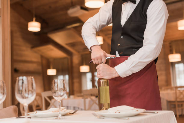 istock waiter opening bottle of wine 875463956