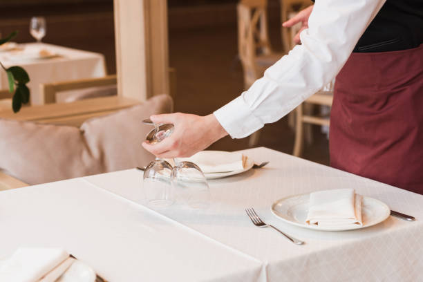 istock waiter putting wineglasses on table 875468382