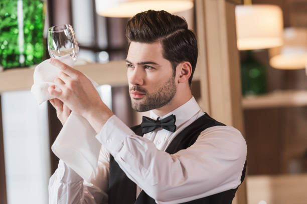 istock waiter looking at clean wineglass 875468668