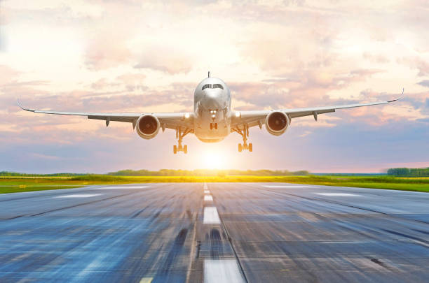 istock Passenger airplane landing at sunset on a runway. 875471294
