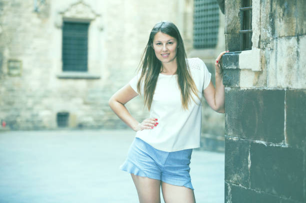 istock Young woman resting against old stone wall 875471630