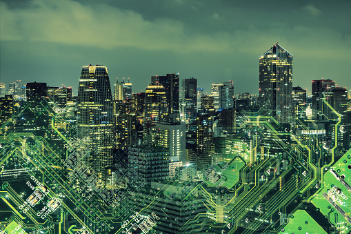 Double exposure of modern cityscape and electric circuit.