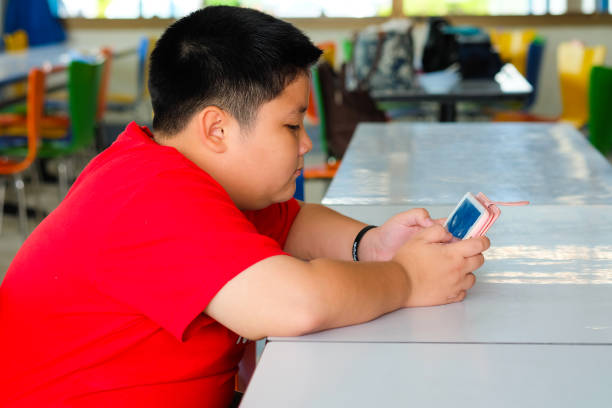 asian child boy are addictive playing tablet and mobile phones, game addiction - adipose cell imagens e fotografias de stock