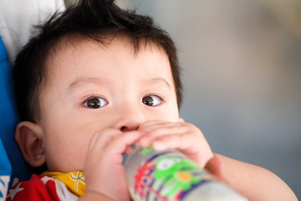 istock Asian child  boys eating milk from bottles and looking 875490278