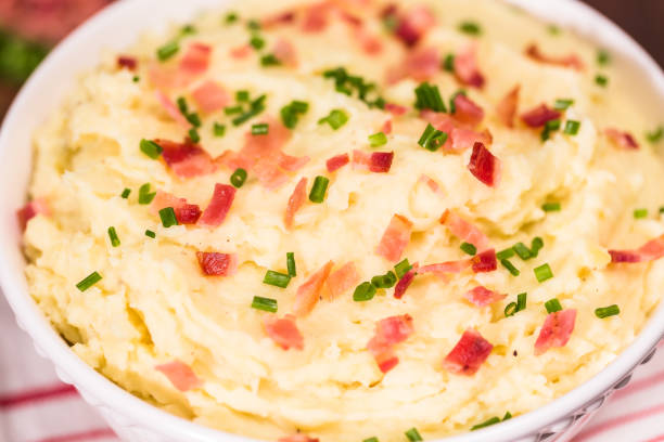 istock Serving bowl with American style creamy mashed potatoes garnished 875503256