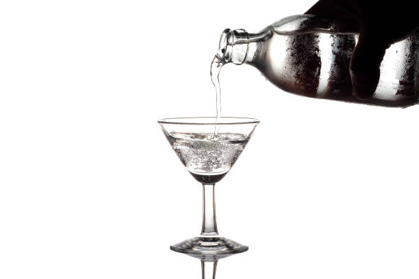 istock Pouring water or soda into a martini glass on white background 875515142