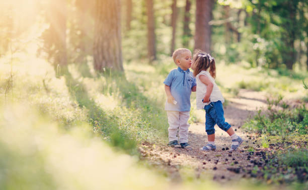 Boy and boy kissing in the forest in summer
