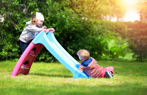 Boy and boy playing on the backyard on sliding