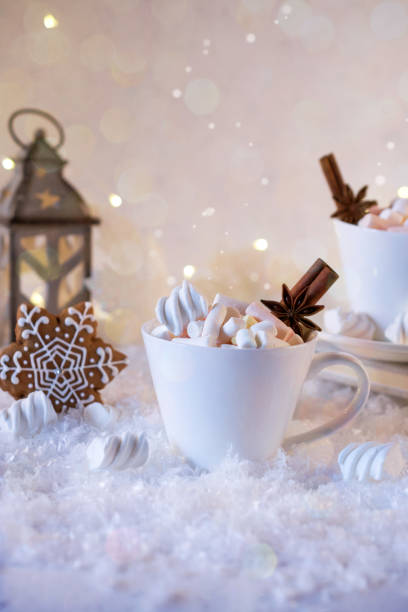 istock Cup of hot beverage with marshmallow and spices on snow background. 875524168