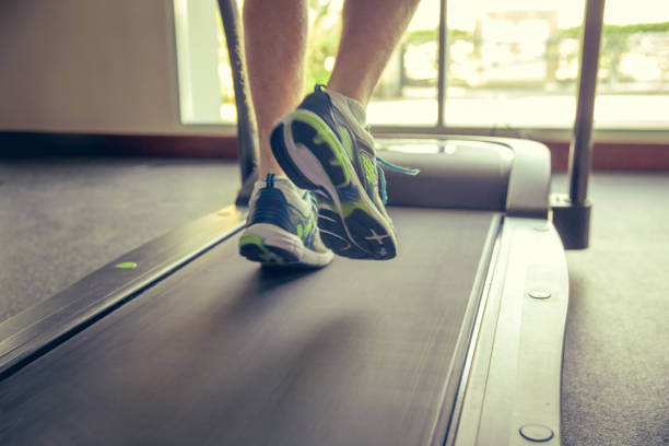istock Close up adult man running on treadmill 875525126