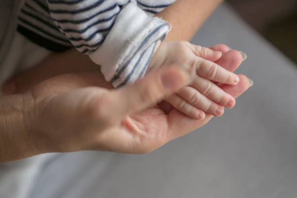 istock Newborn baby lying in her mother's arms. 875530832