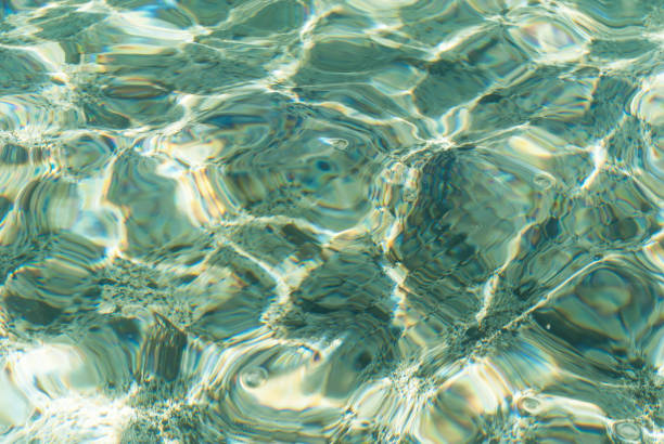 istock Refraction of light in clear water with small waves. Background 875531300