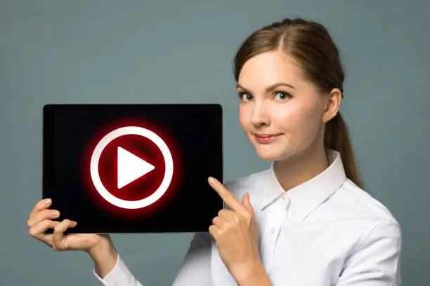 Photo of Young woman showing movie play button.