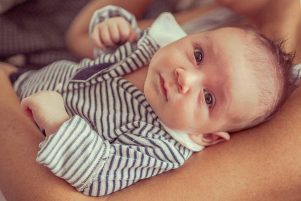 istock Newborn baby lying in her mother's arms. 875536836