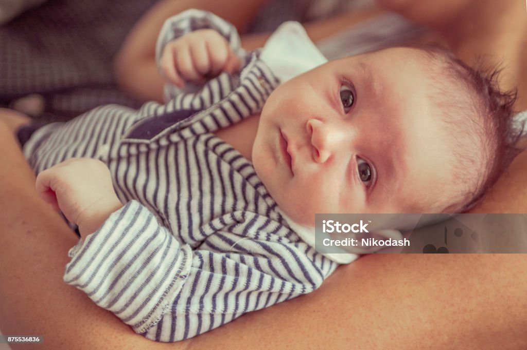 Newborn baby lying in her mother's arms. Newborn baby lying in her mother's arms. Shallow depth of field Adult Stock Photo