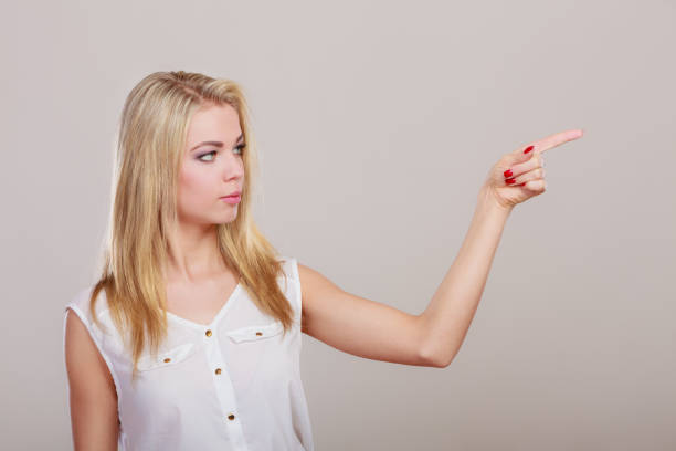 istock woman showing copy space pointing with finger 875540498