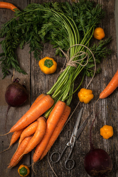 istock Red carrot on wooden background table. Top view 875541898