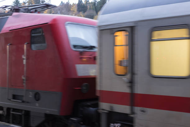 trainstation with train passing by and rails with infrastructure beside in south germany city near munich and stuttgart
