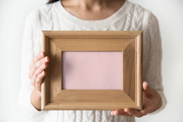 istock A woman holding blank wooden picture frame 875552128