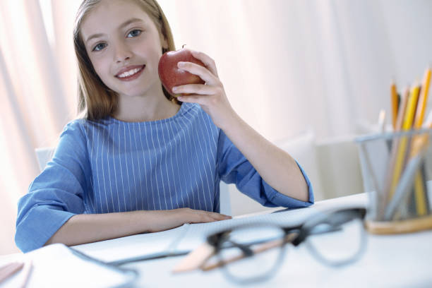 istock Responsible pupil holding a tasty apple 875554476